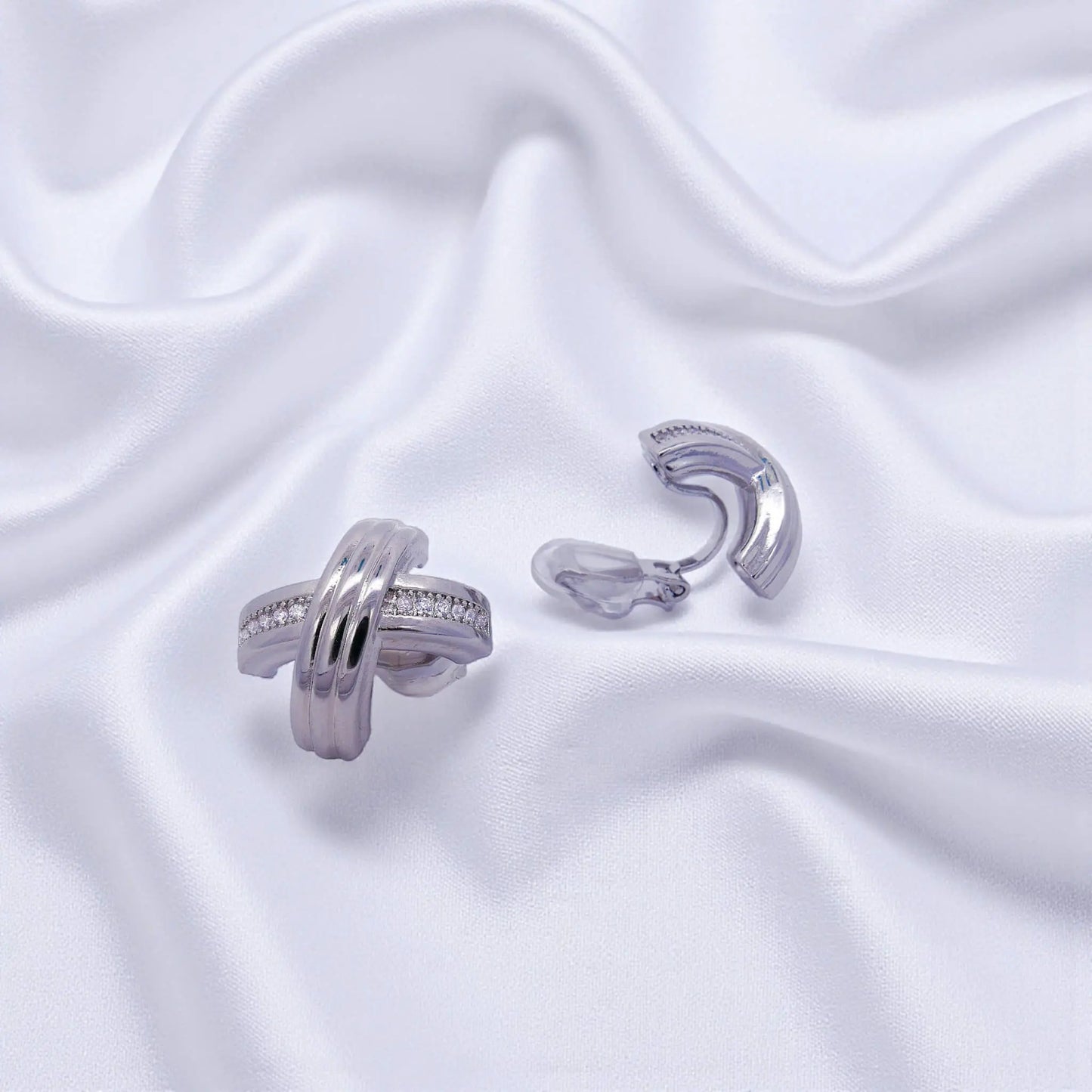 Zilverkleurige cross design oorbellen met clipsen en zirkonia stenen  Victoria Valenza