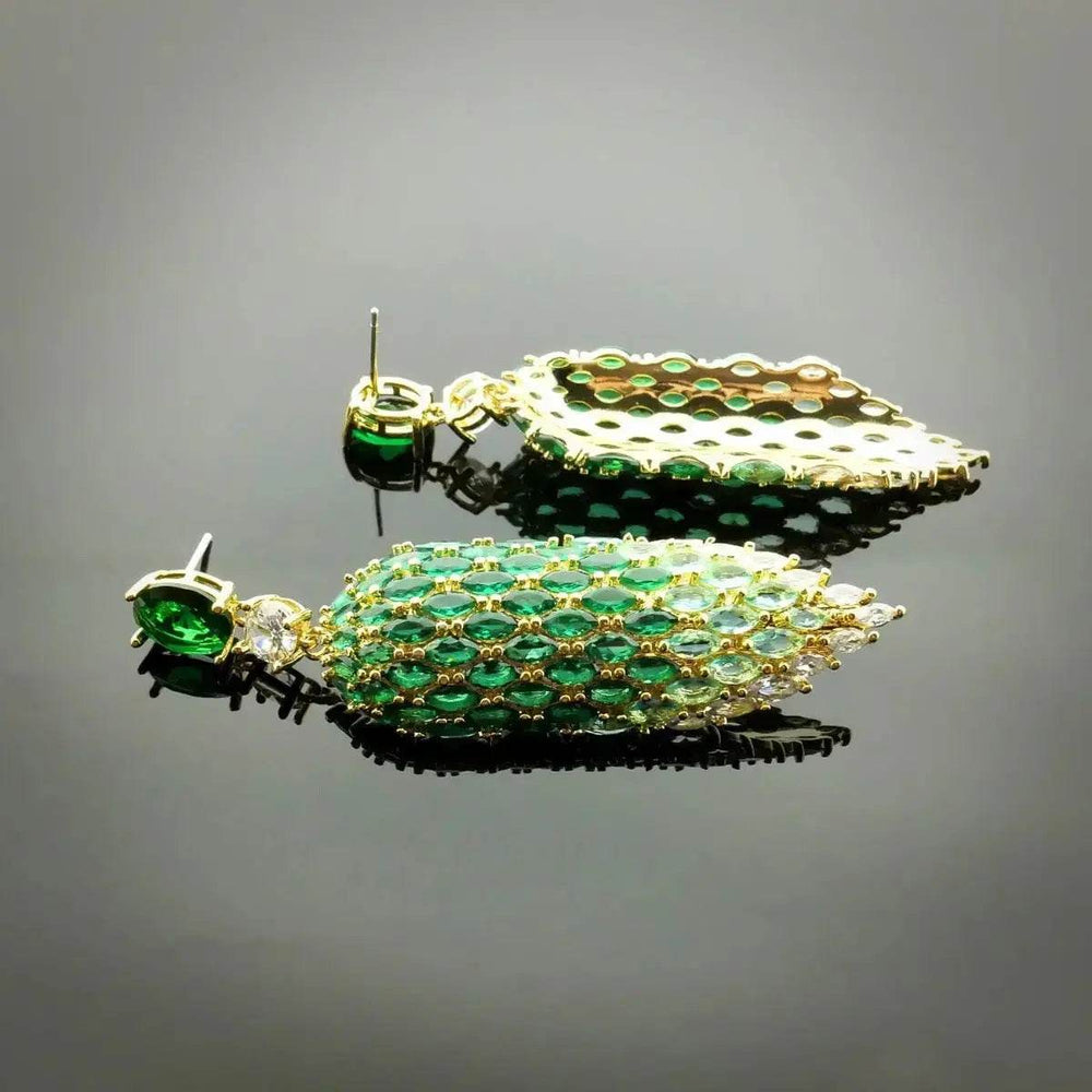 
                      
                        Goudkleurige blad oorbellen met groene zirkonia's - Victoria Valenza
                      
                    