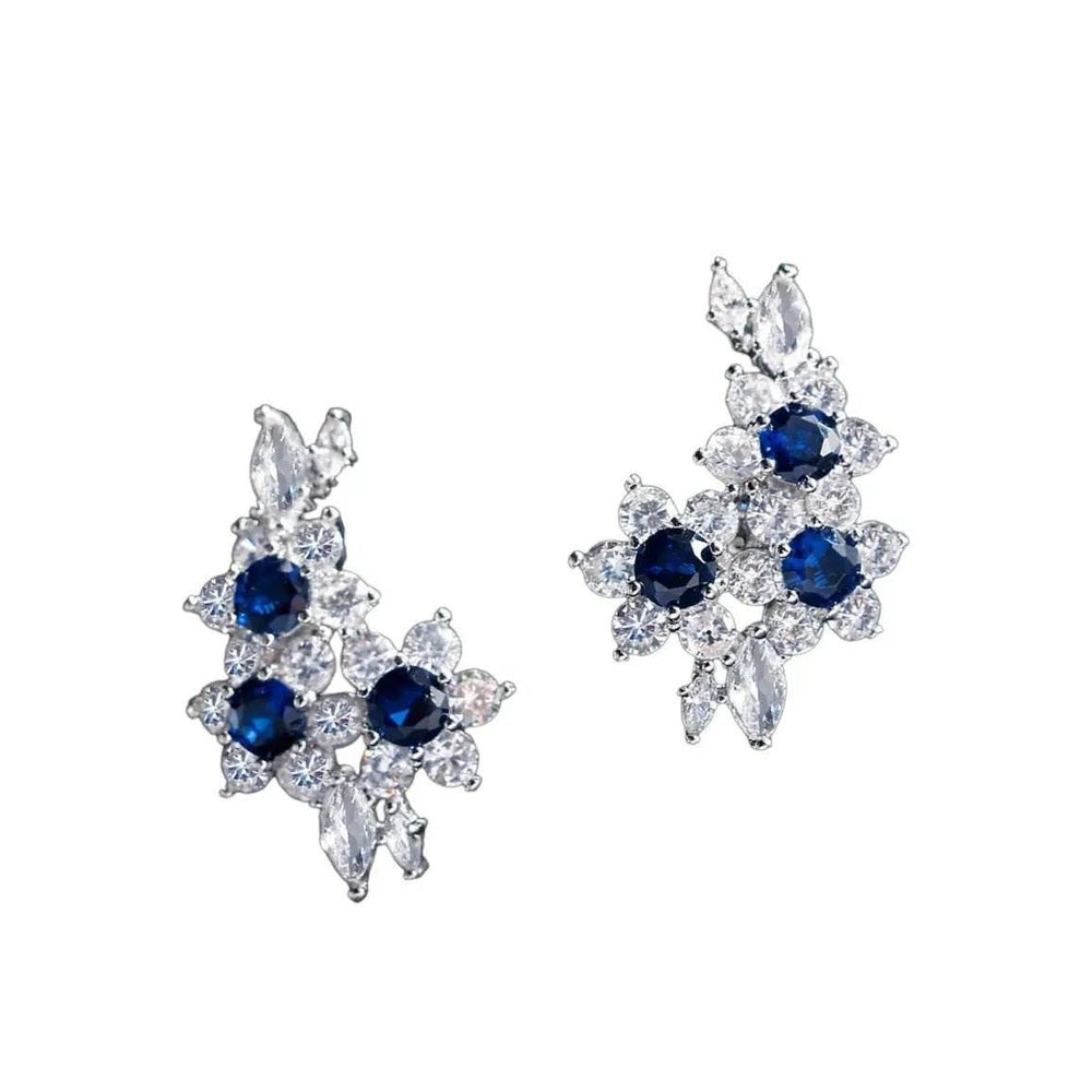 
                      
                        Zilverkleurige bloemvormige oorbellen met blauwe en witte zirkonia's - Victoria Valenza
                      
                    