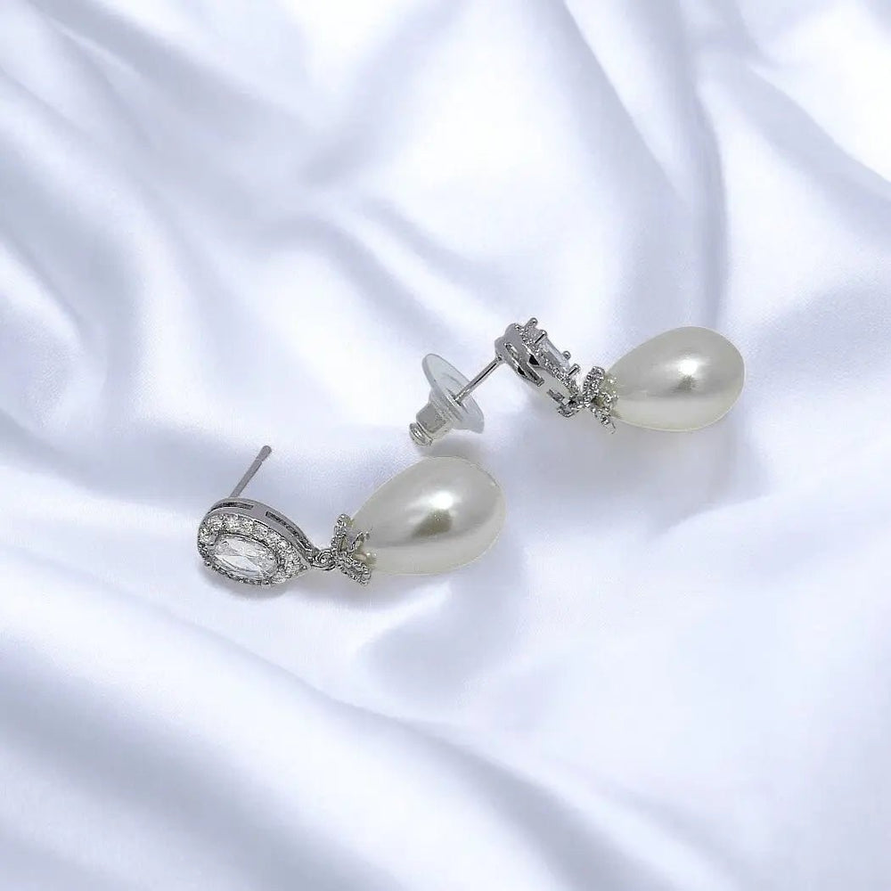 
                      
                        Zilverkleurige druppel oorbellen met zirkonia stenen en parels  Victoria Valenza
                      
                    
