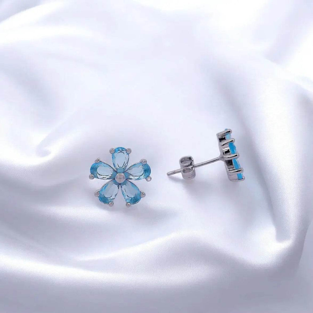 
                      
                        Zilverkleurige bloem oorbellen met blauwe zirkonia stenen - Victoria Valenza
                      
                    