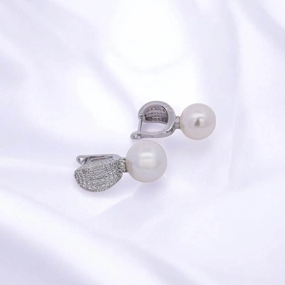 
                      
                        Zilverkleurige oorbellen met parels en pavé zirkonia stenen - Victoria Valenza
                      
                    