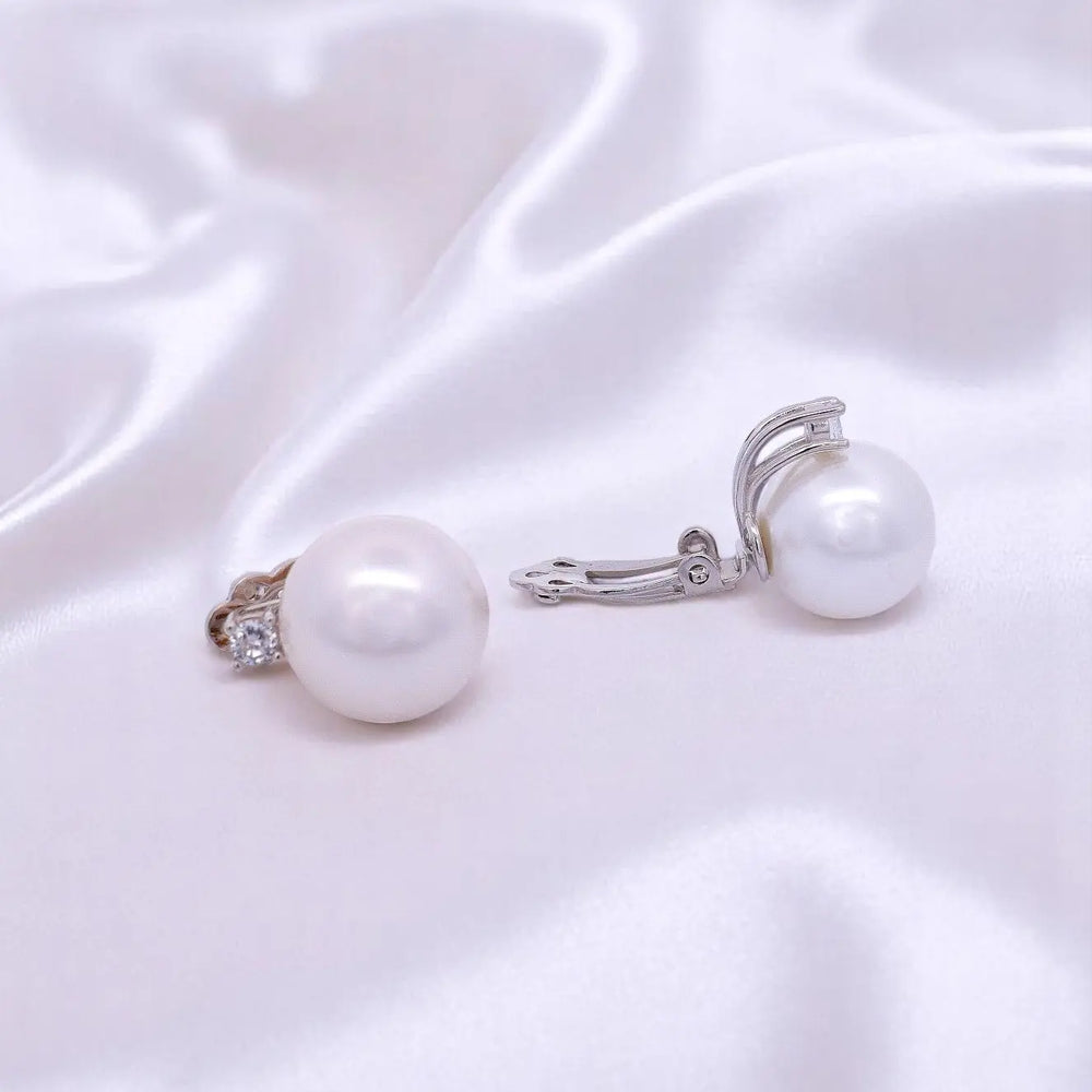 
                      
                        Zilveren clip oorbellen met parels 14 mm en zirkonia stenen.  Victoria Valenza
                      
                    