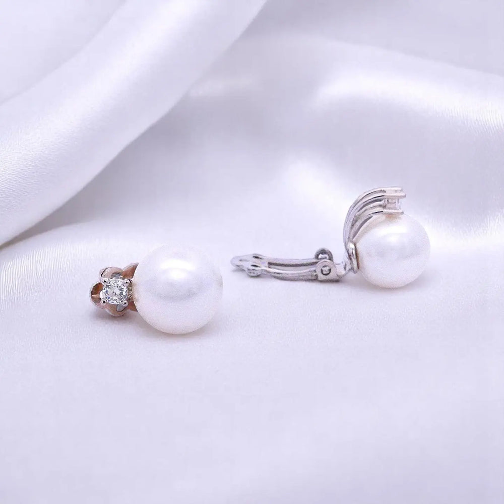 
                      
                        Zilveren clip oorbellen met parels 12 mm en zirkonia stenen.  Victoria Valenza
                      
                    