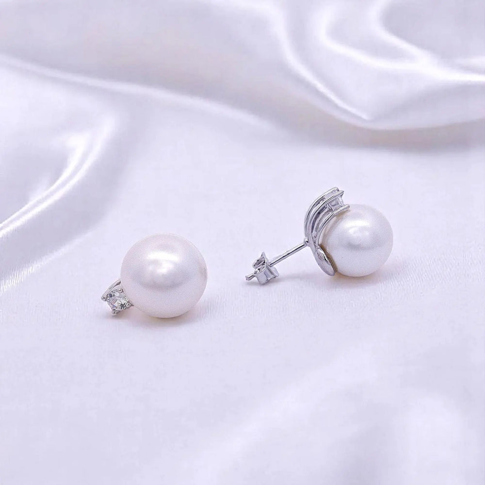 
                      
                        Zilveren oorbellen met parels 12 mm en zirkonia stenen.  Victoria Valenza
                      
                    