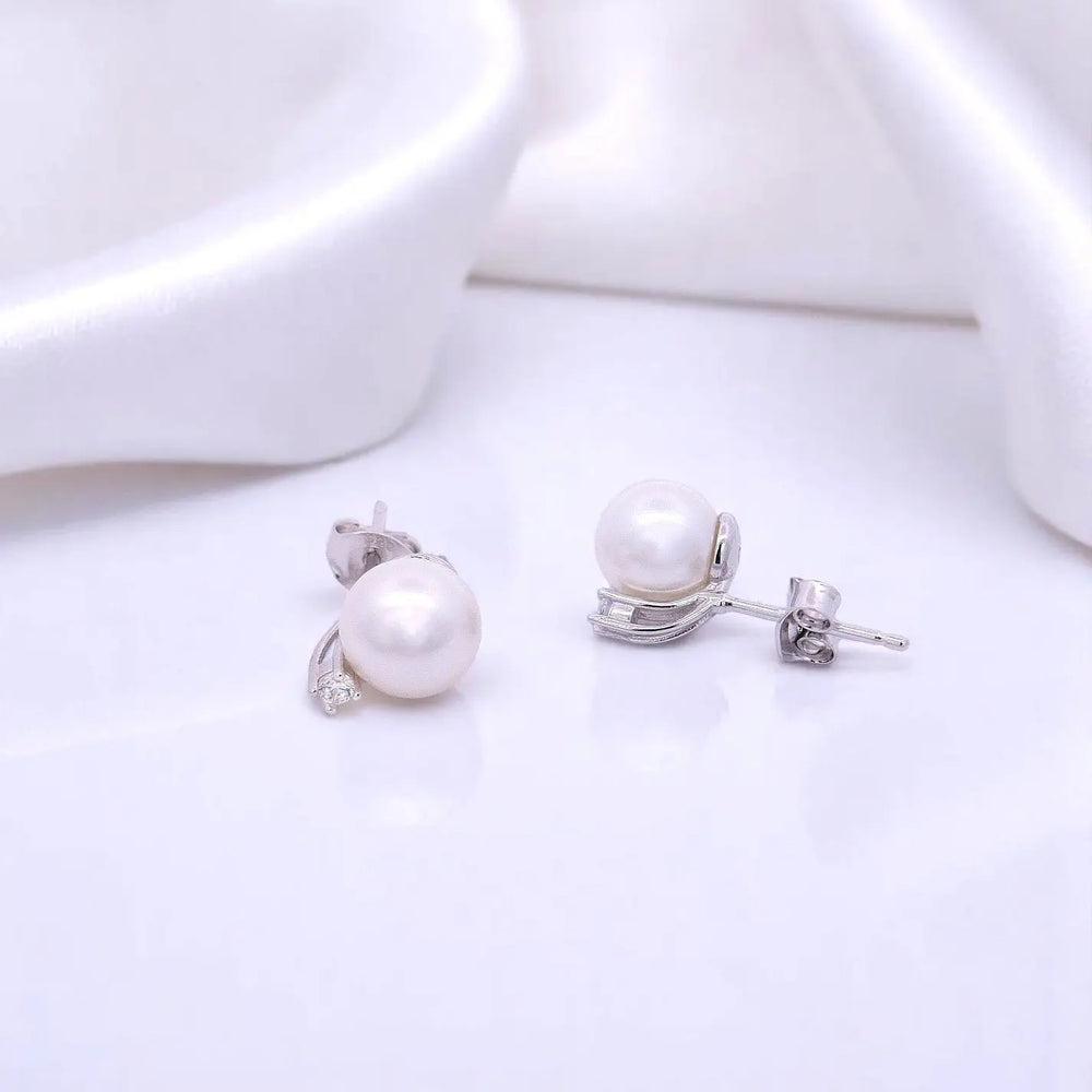 
                      
                        Zilveren oorbellen met parels 8 mm en zirkonia stenen.  Victoria Valenza
                      
                    