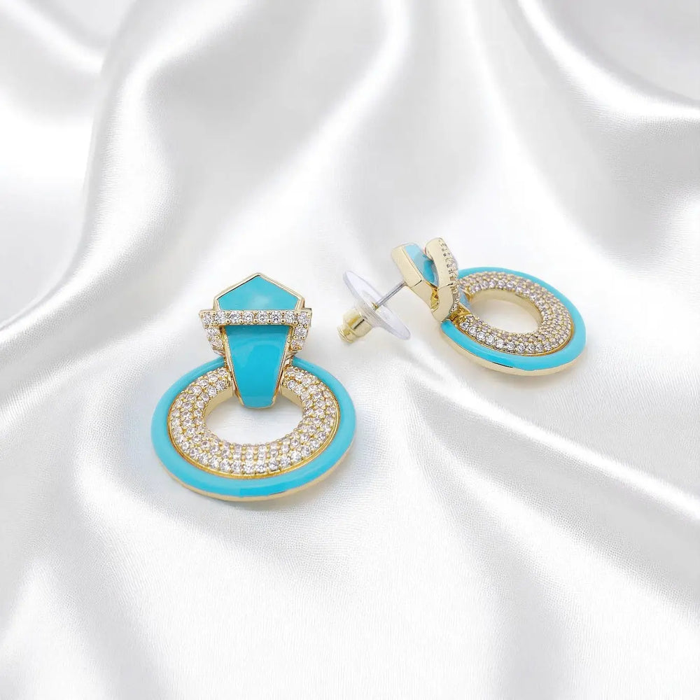
                      
                        Vergulde ronde oorbellen met zirkonia stenen en turquoise emaille  Victoria Valenza
                      
                    