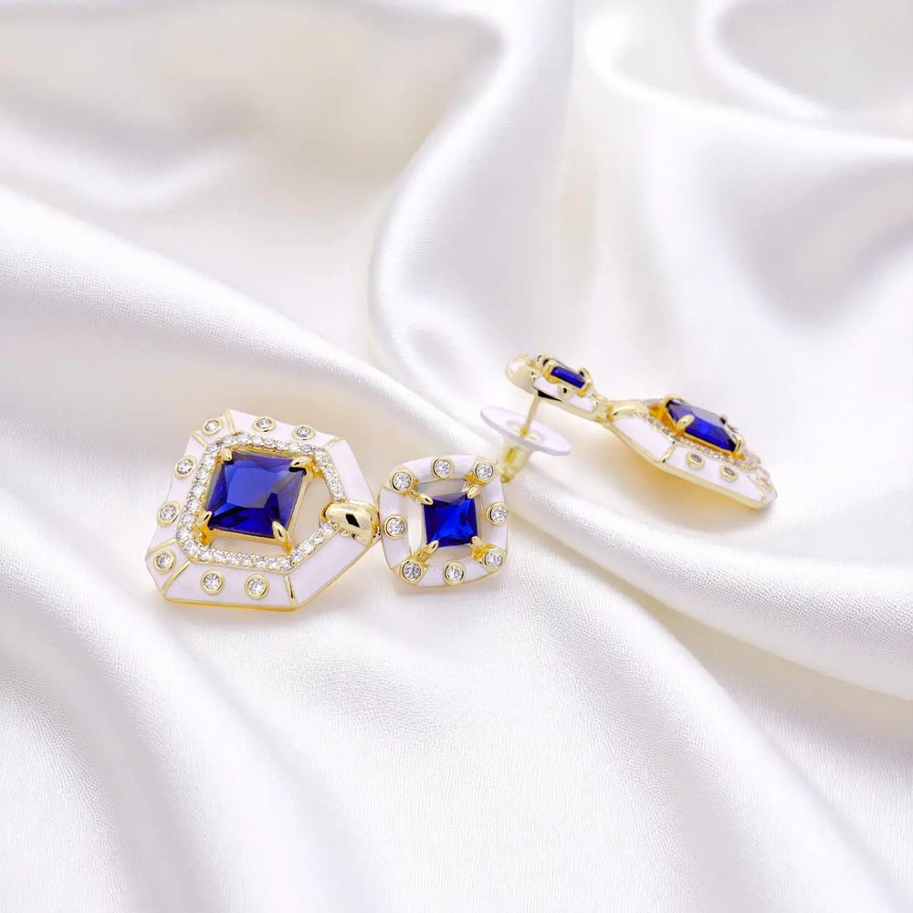 
                      
                        Vergulde oorbellen met blauwe en witte zirkonia stenen en witte emaille  Victoria Valenza
                      
                    