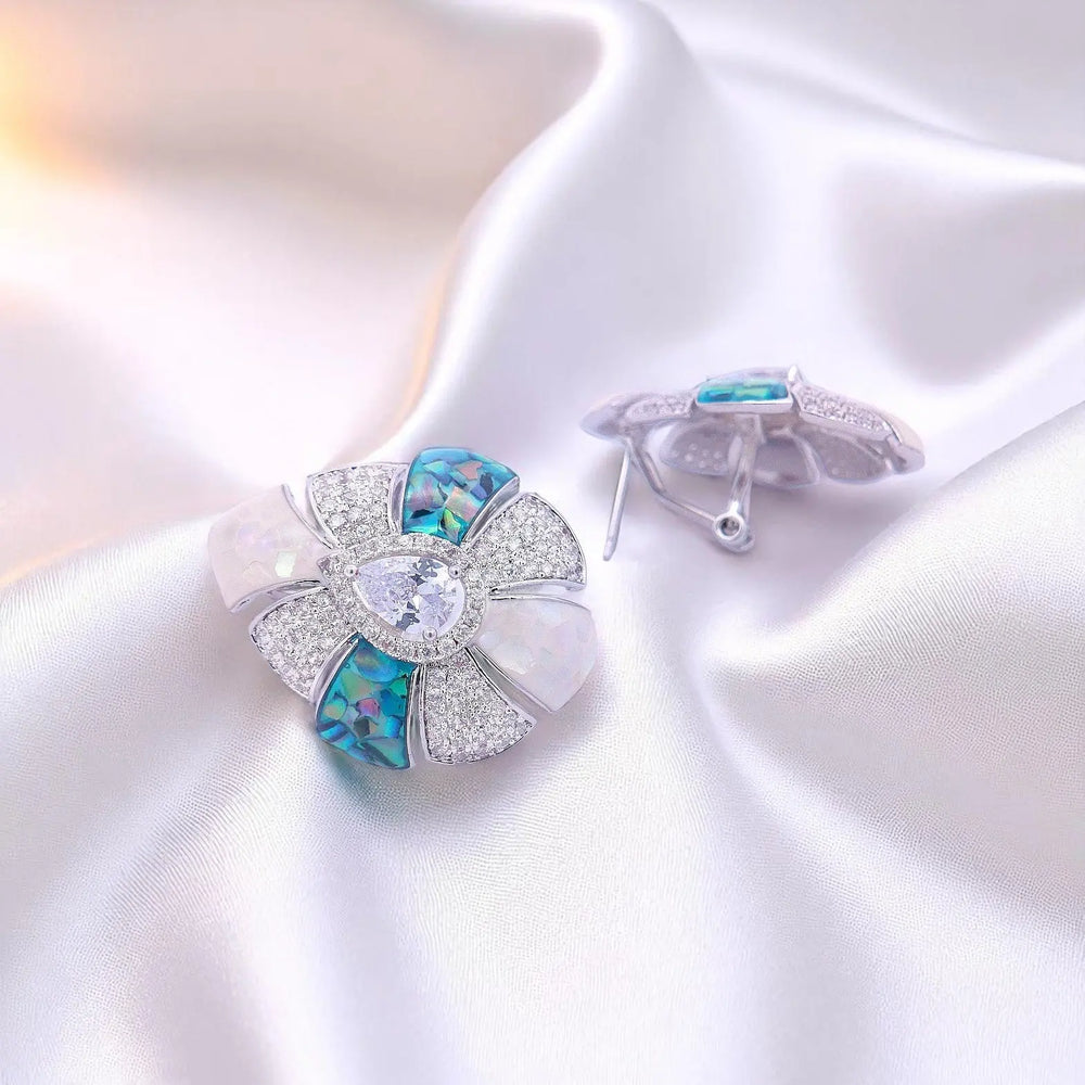 
                      
                        Zilverkleurige gerhodineerde druppel oorbellen met blauw-groene en witte parelmoer en witte zirkonia stenen  Victoria Valenza
                      
                    