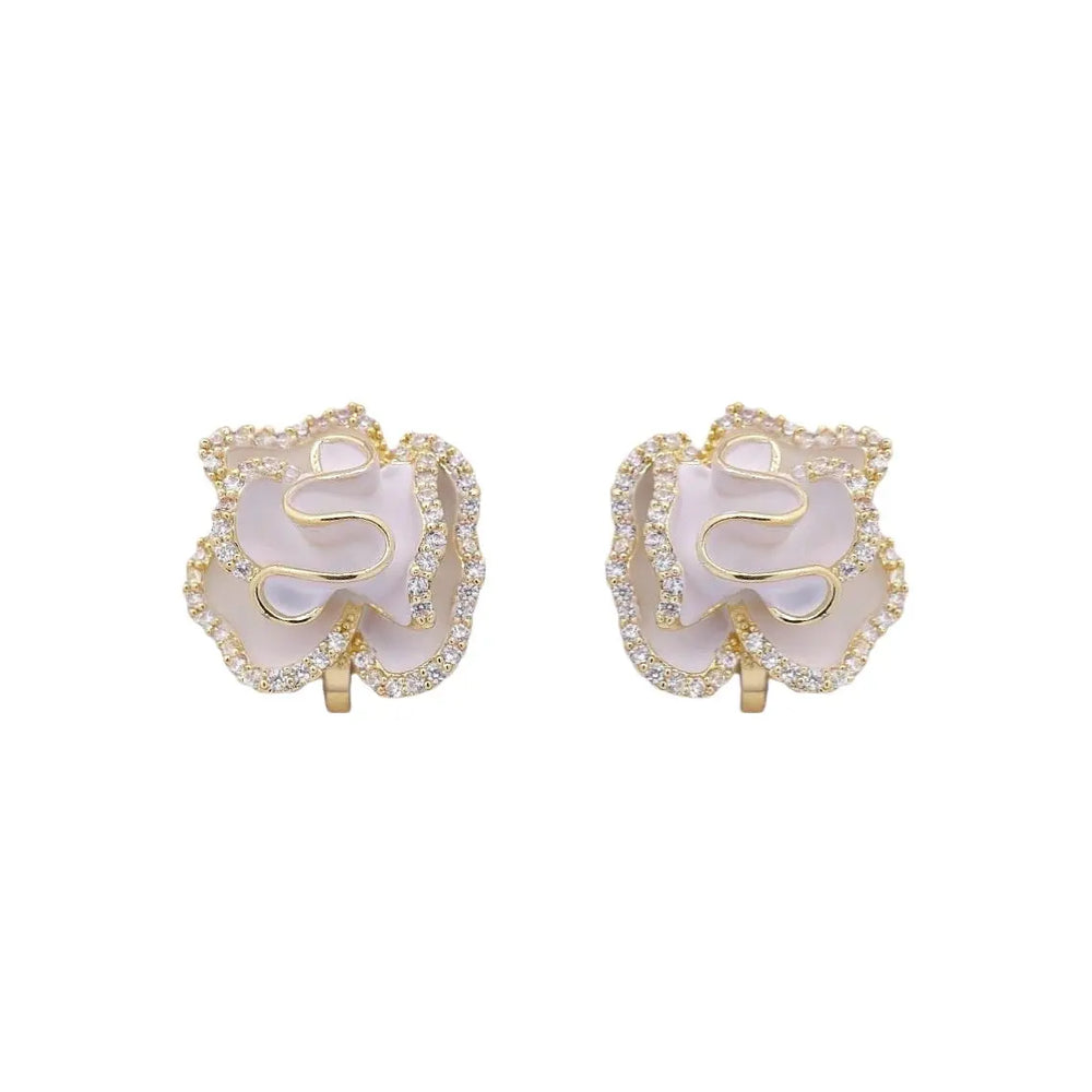 
                      
                        Goudkleurige camellia oorbellen met clipsen, witte emaille en zirkonia stenen  Victoria Valenza
                      
                    