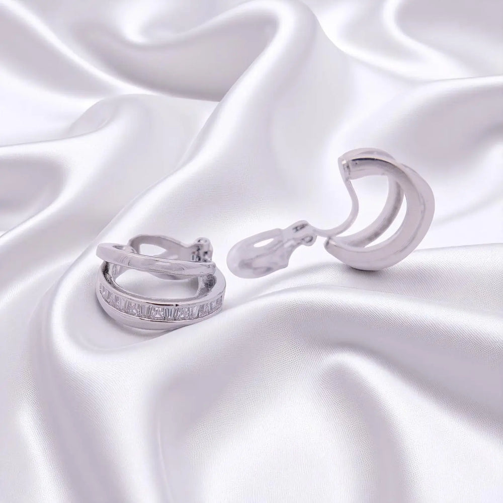
                      
                        Zilverkleurige oorbellen met clipsen met trapezium zirkonia stenen  Victoria Valenza
                      
                    