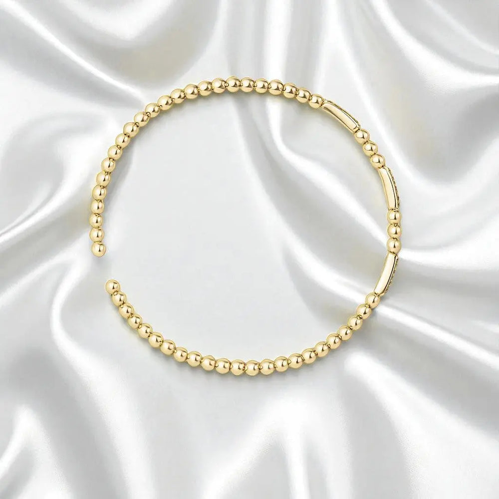 
                      
                        Goudkleurige bolletjes flexarmband met zirkonia stenen  Victoria Valenza
                      
                    