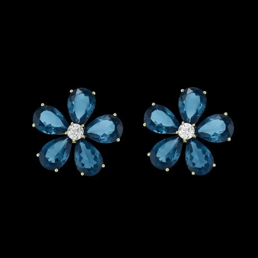 Goudkleurige bloem oorbellen met blauwe zirkonia stenen  Victoria Valenza