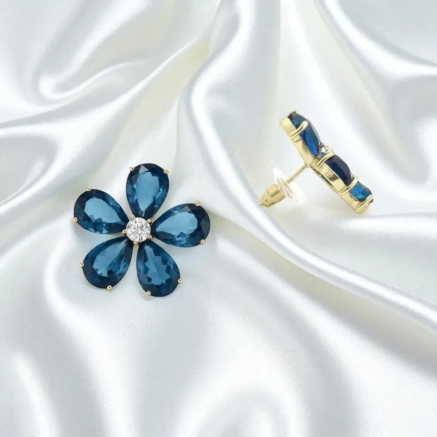 
                      
                        Goudkleurige bloem oorbellen met blauwe zirkonia stenen  Victoria Valenza
                      
                    