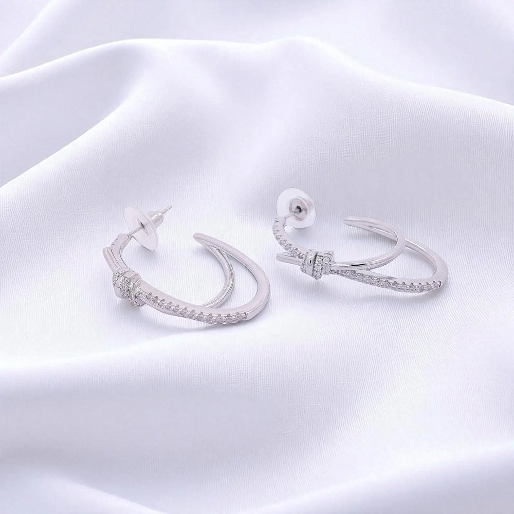 
                      
                        Zilverkleurige knot oorbellen met zirkonia stenen  Victoria Valenza
                      
                    