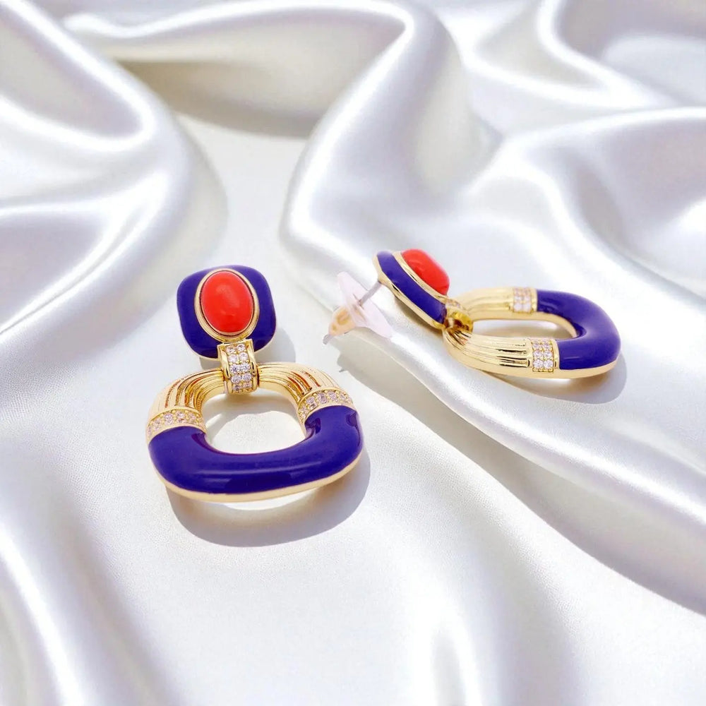 
                      
                        Goudkleurige oorbellen met koraal, blauwe emaille en zirkonia stenen  Victoria Valenza
                      
                    