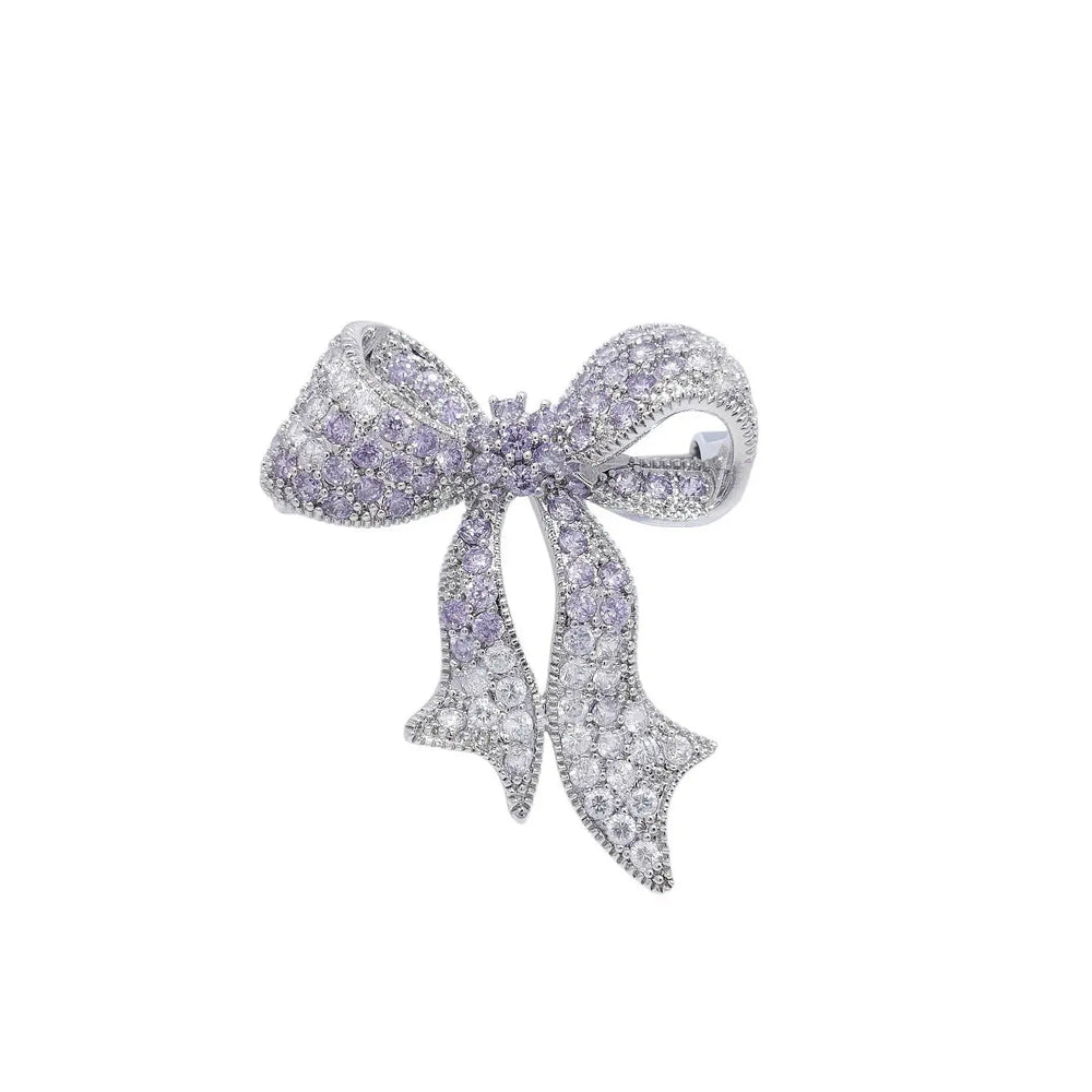 
                      
                        Zilverkleurige strik broche pavé paarse en witte zirkonia stenen  Victoria Valenza
                      
                    