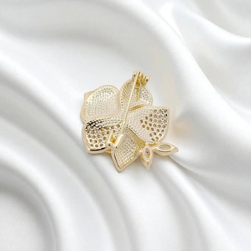 
                      
                        Goudkleurige orchidee broche met zoetwater parel, emaille en zirkonia stenen  Victoria Valenza
                      
                    