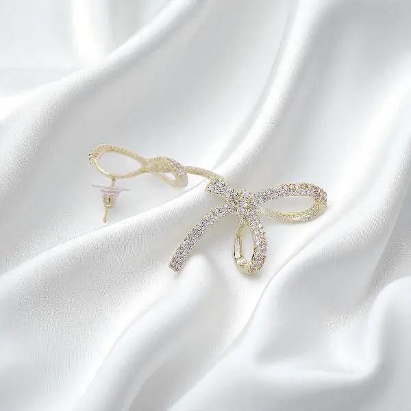 
                      
                        Goudkleurige grote strik oorbellen met zirkonia stenen  Victoria Valenza
                      
                    