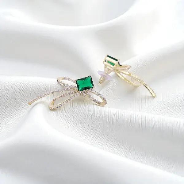 
                      
                        Goudkleurige strik oorbellen met groene zirkonia stenen  Victoria Valenza
                      
                    