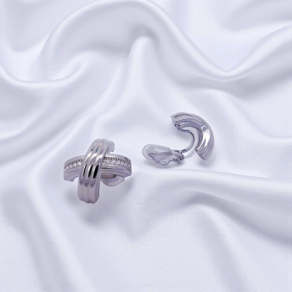 
                      
                        Zilverkleurige cross design oorbellen met clipsen en zirkonia stenen  Victoria Valenza
                      
                    