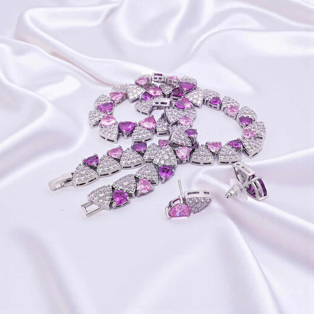 
                      
                        Zilverkleurige collier en oorbellen met paarse en roze zirkonia stenen  Victoria Valenza
                      
                    