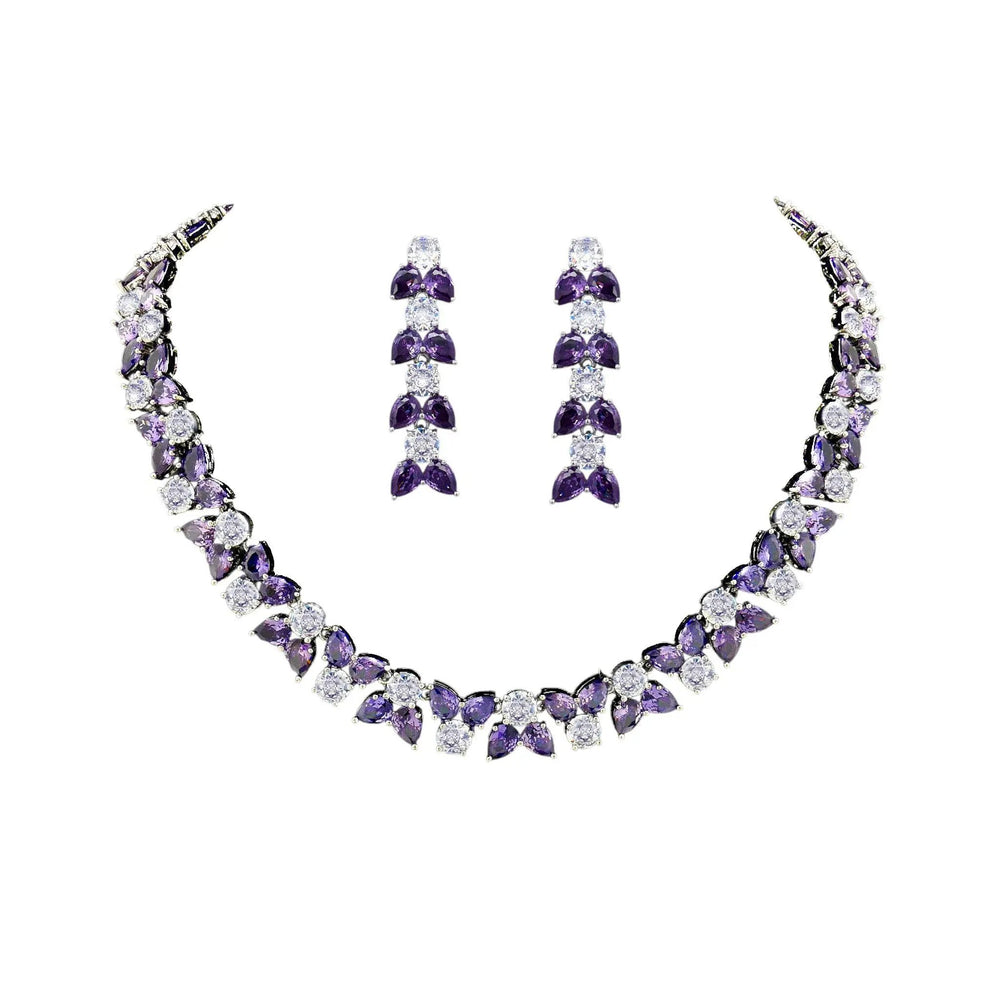 
                      
                        Zilverkleurige collier en oorbellen met paarse zirkonia stenen  Victoria Valenza
                      
                    