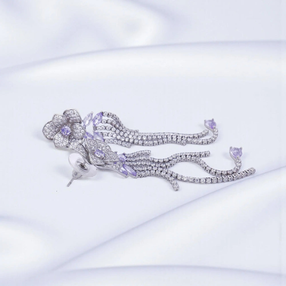 
                      
                        Zilverkleurige lange bloem oorbellen met paarse zirkonia stenen  Victoria Valenza
                      
                    