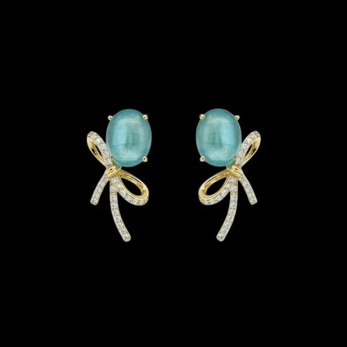 Goudkleurige strik oorbellen met aquamarijnkleurige cabochon zirkonia stenen