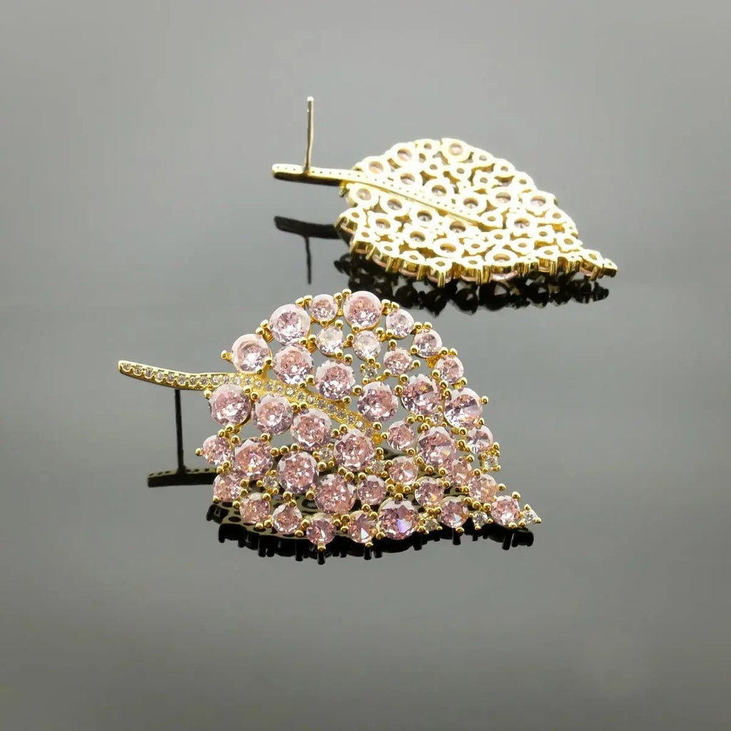 Detail van roze zirkonia stenen op goudkleurige oorbellen 