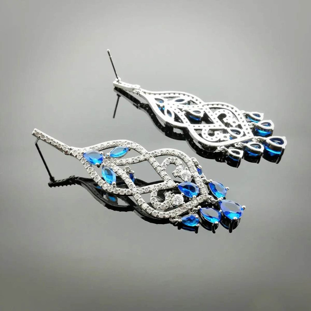 
                      
                        Zilverkleurige chandelier oorbellen met blauwe zirkonia's - Victoria Valenza
                      
                    